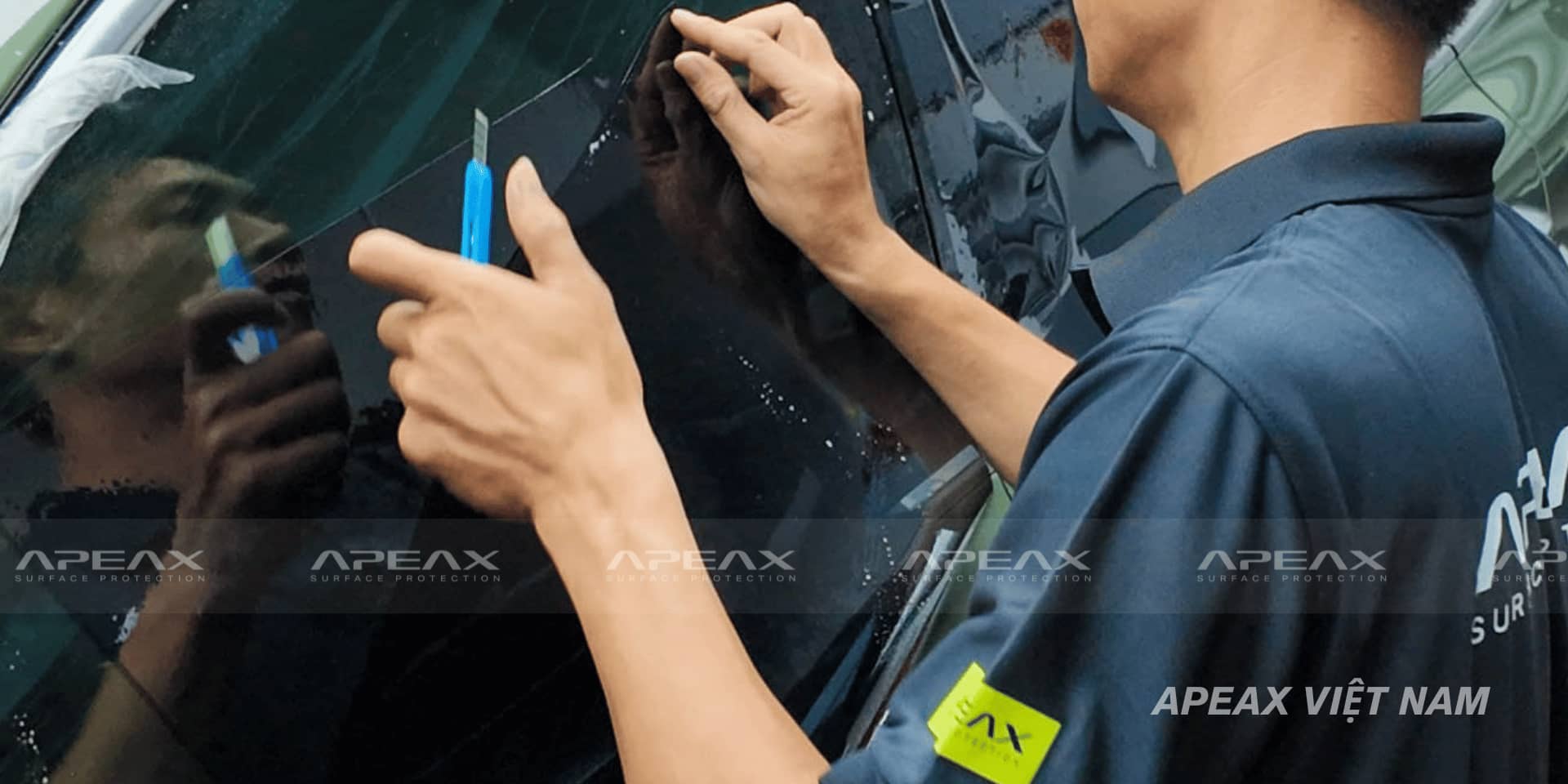 Kỹ thuật viên đang đo cắt phim cách nhiệt ở bên ngoài xe.